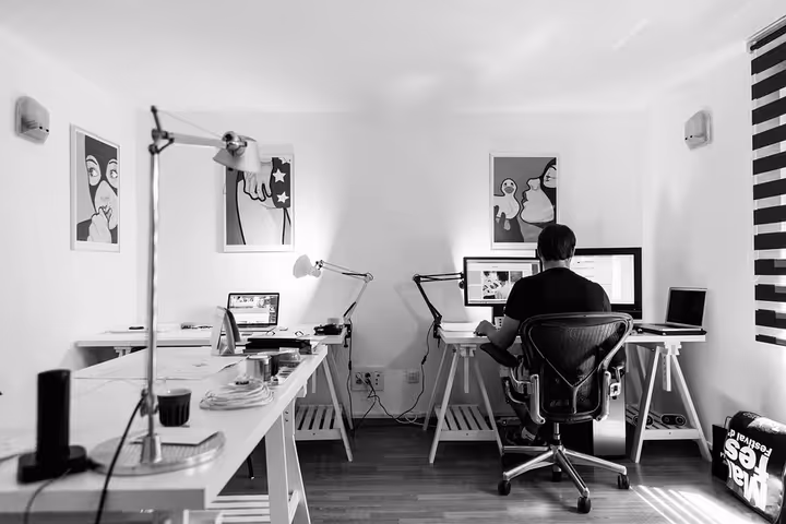 Projektant pracuje nad makietą strony WordPress w Figma na dwóch monitorach