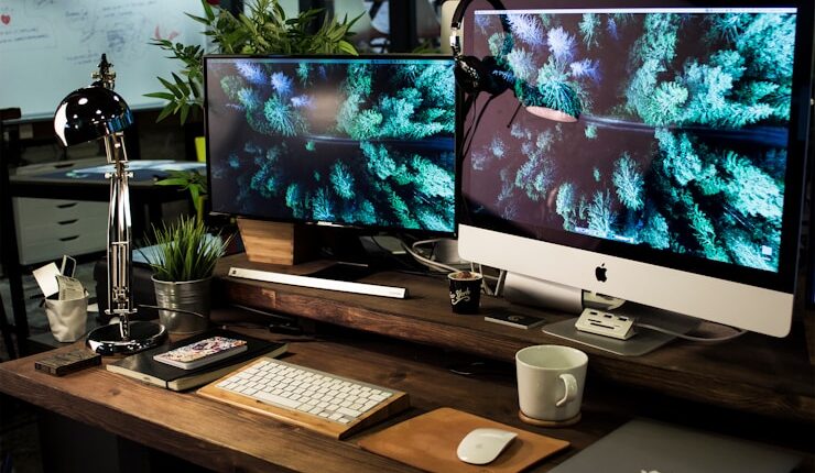 two computer monitors turned on with the same wallpaper