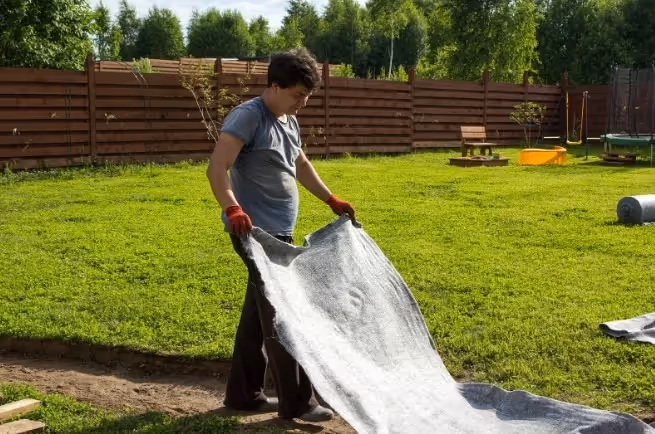 Rolka geowłókniny rozłożona na przygotowanym podłożu przed ułożeniem ścieżki